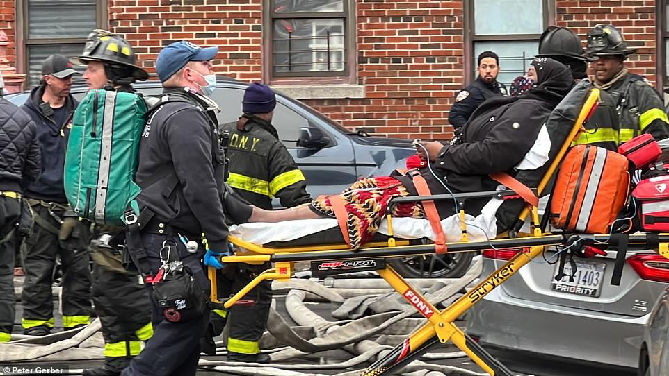 Firefighters rescue victims from the fire in the Bronx on Sunday
