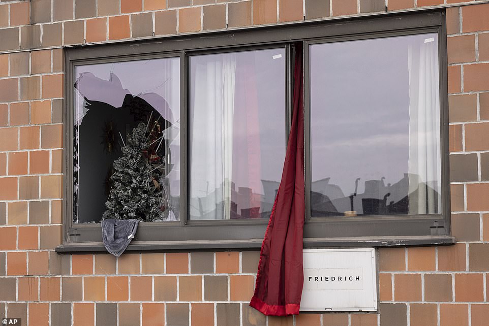 A curtain hangs outside a window at an apartment building in the Bronx on Sunday. Fire crews pulled out victims out of windows