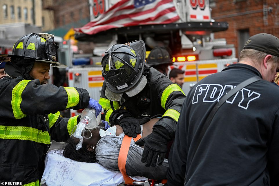 Emergency personnel from the FDNY provide medical aid as they respond to an apartment building fire in the Bronx borough of New York