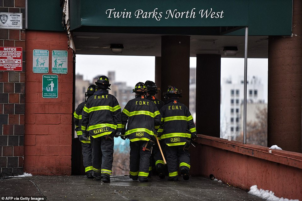 Firefighters work outside an apartment building after a fire in the Bronx, on January 9, 2022, in New York.