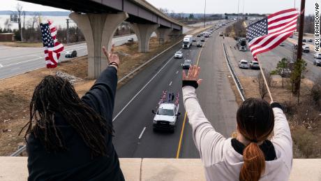 Supporters wave as a convoy of trucks and other vehicles travel I-495 near the Woodrow Wilson Bridge, to protest Covid-19 mandates and other issues on Sunday, March 6, in Fort Washington, Maryland.