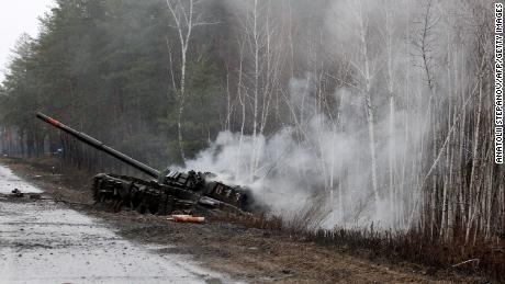 Smoke rises from a Russian tank destroyed by the Ukrainian forces on the side of a road in Lugansk region on February 26, 2022.