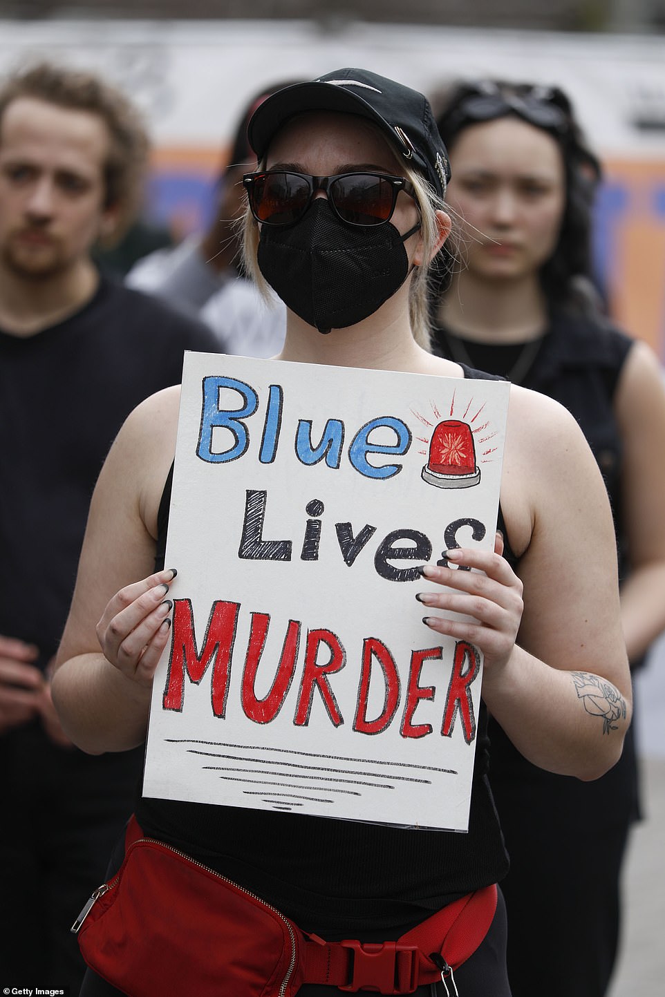 Protesters hold signs that read 'Blue Lives Murder' following the fatal shooting of Lyoya