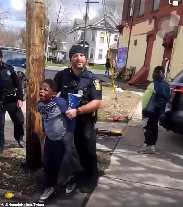 The video was shot by a local resident who appeared incredulous at how officers were treating the boy who was in tears as he was frogmarched towards a waiting patrol car