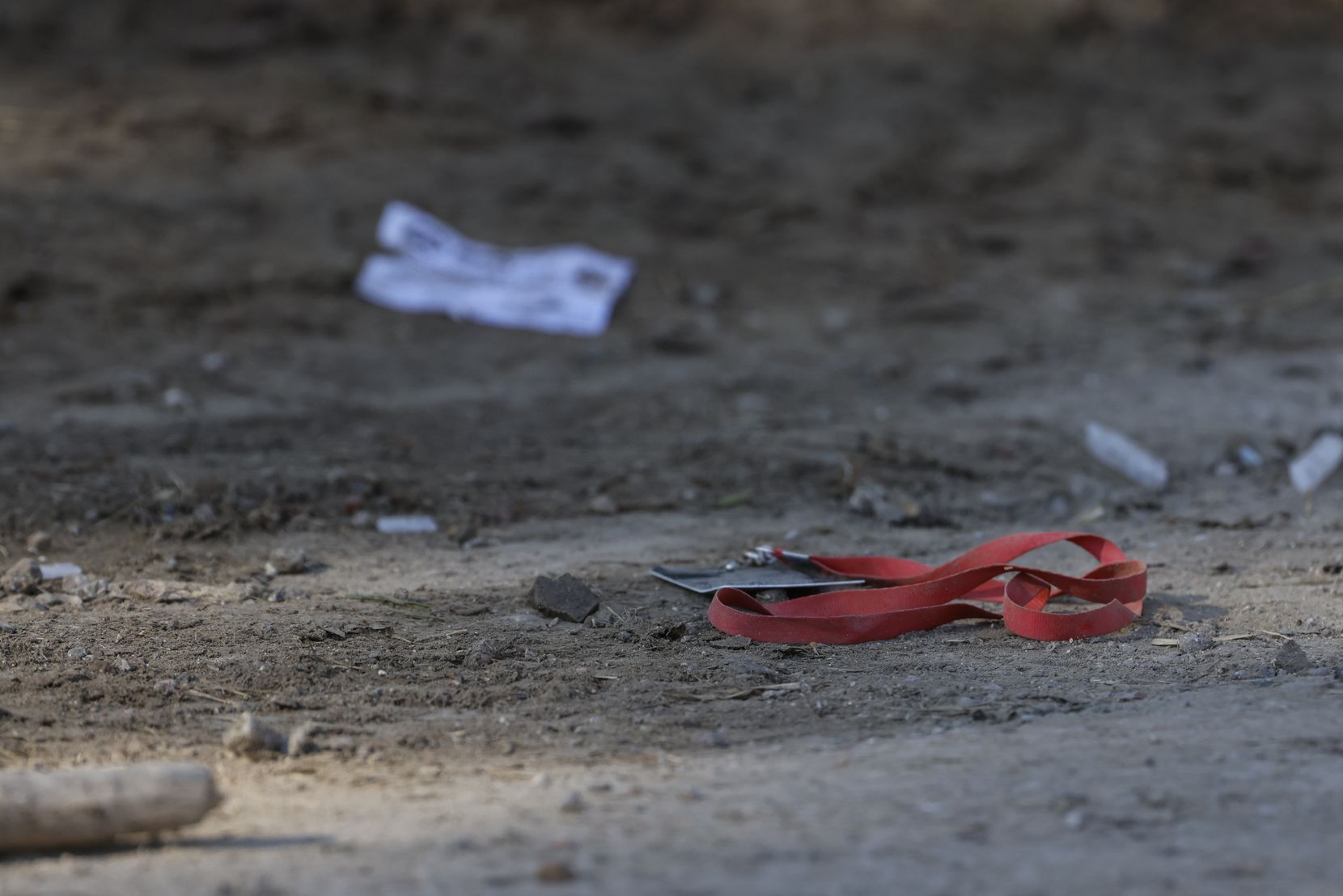 A lanyard with a VIP pass on it lays on the ground Sunday, near where a man was fatally shot...