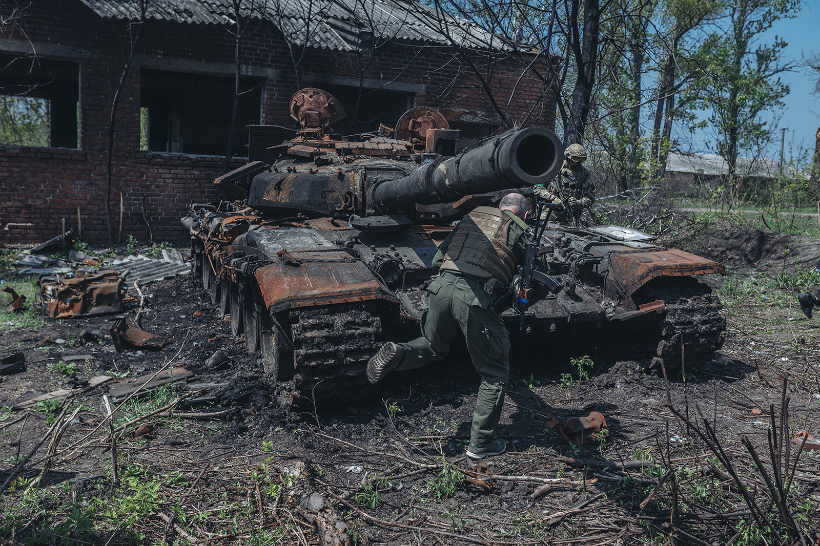 Ukrainian soldiers next to a destroyed Russian tank on the outskirts of Kharkiv, Ukraine, on May 8.