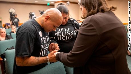 John Lucio, left, prays with his wife, Michelle Lucio, center, and Jennifer Allmon, executive director of the Texas Catholic Conference of Bishops, before a hearing about his mother by the Interim Study Committee on Criminal Justice Reform.