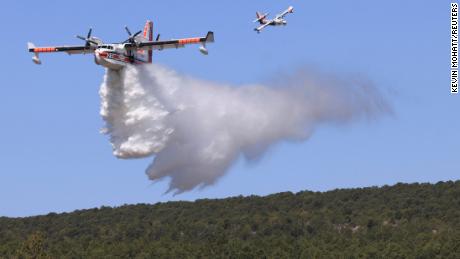 A plane drops water Wednesday to combat the Hermits Peak/Calf Canyon Fire.